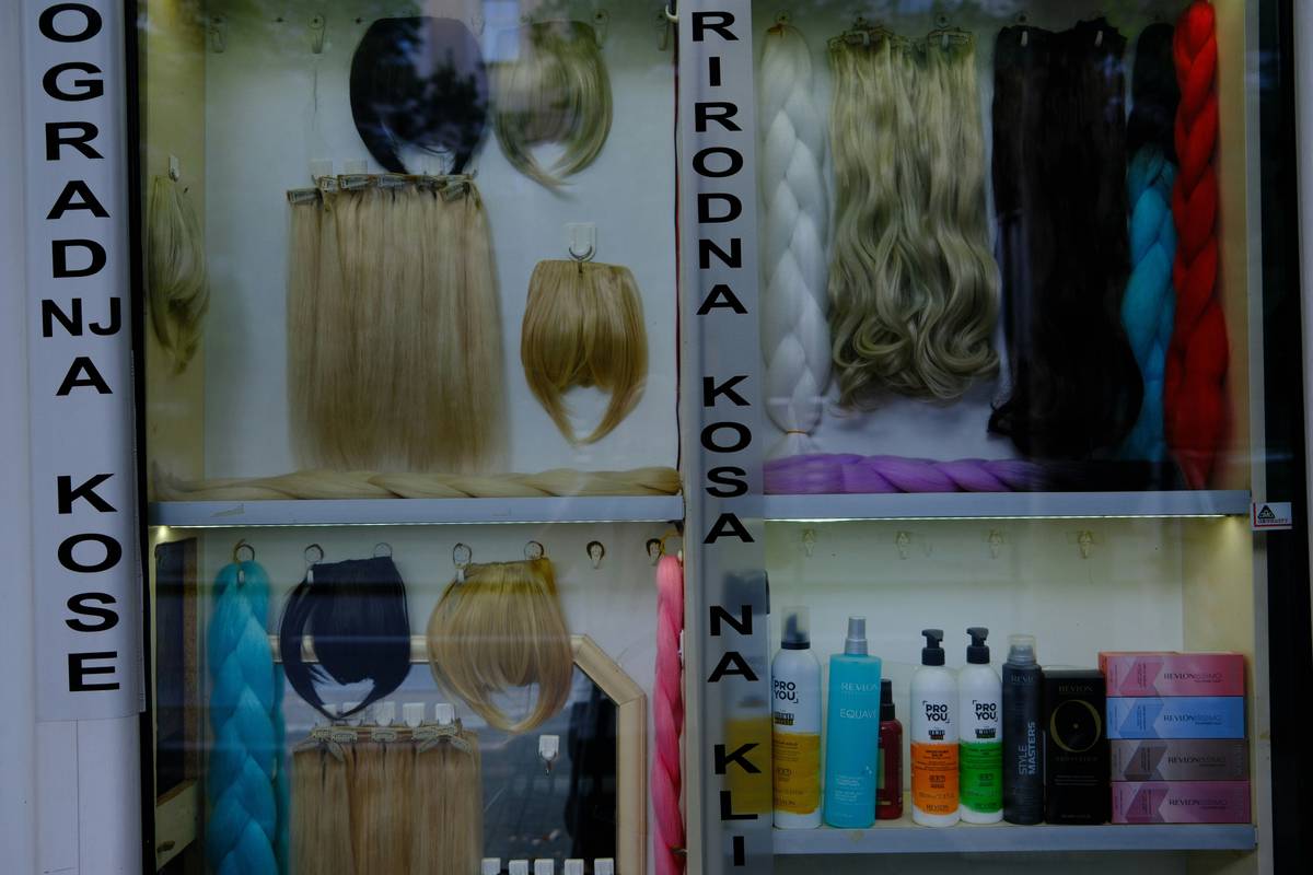 Woman applying volumizing hair spray at roots for lift and texture
