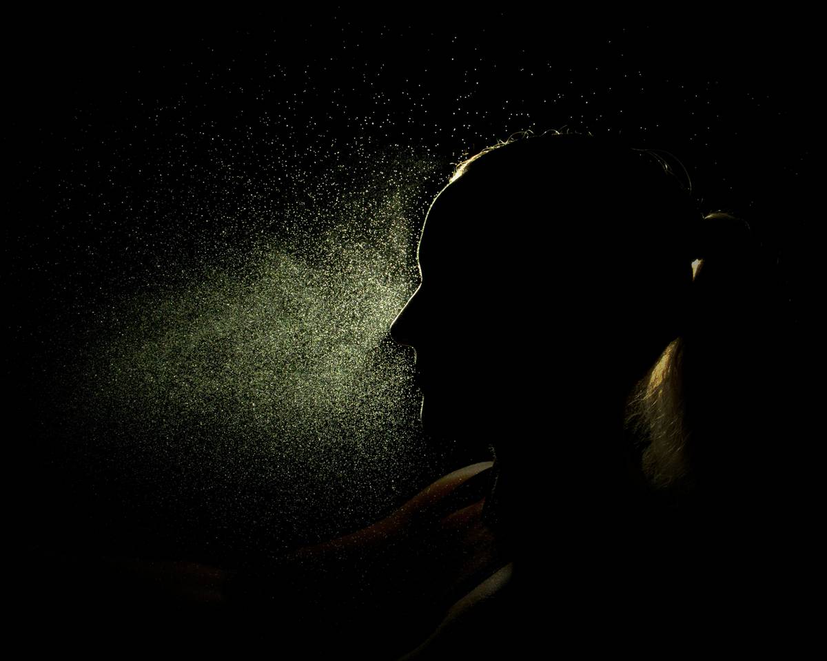 Woman applying hair fortifying mist to damp hair to strengthen strands and prevent breakage